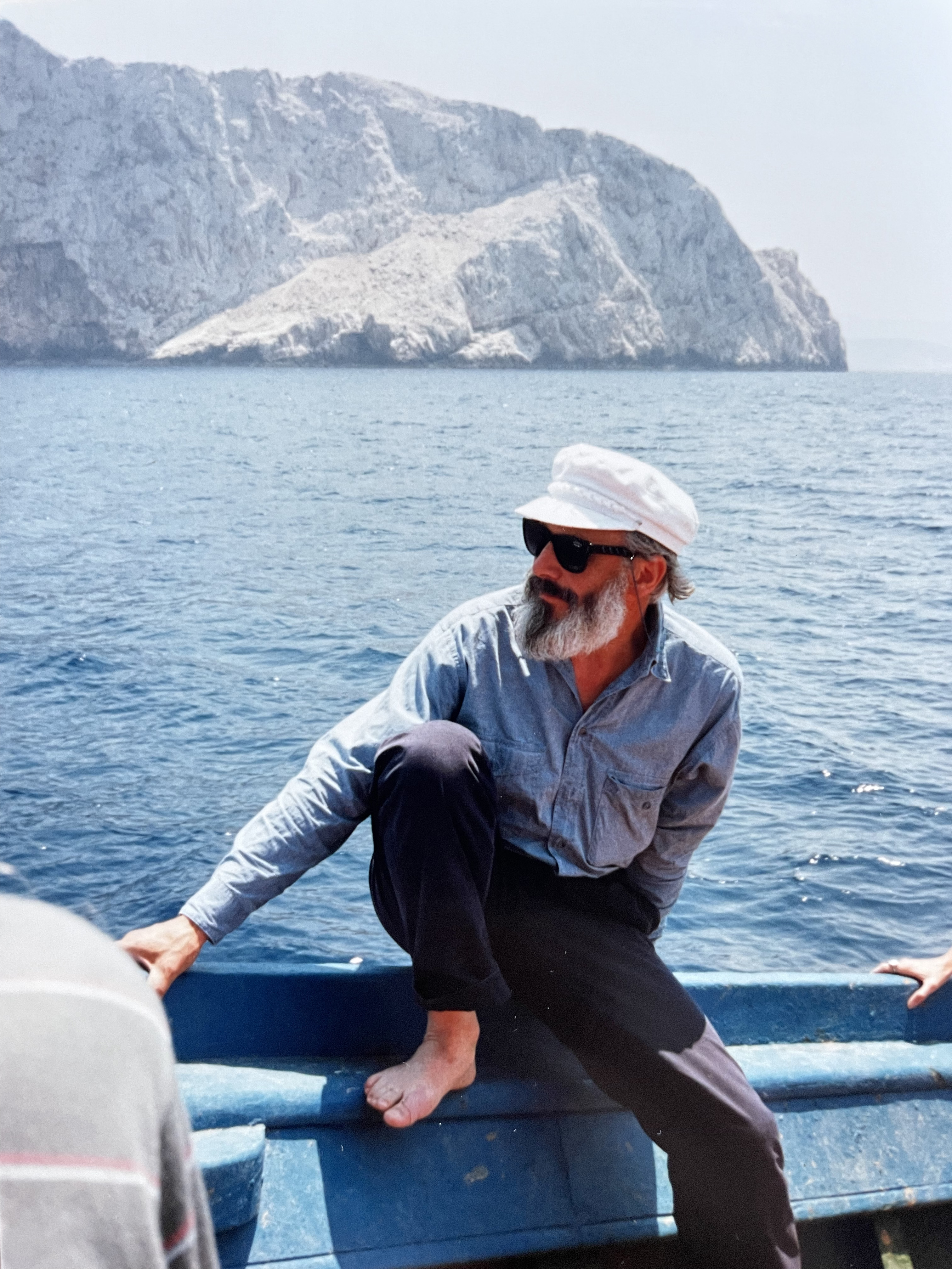 An image of Henry matthews riding a fishing boat, caique, on Amorgos